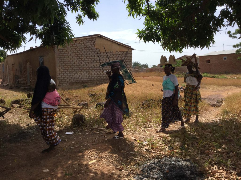 Malian women bring chairs to lunch